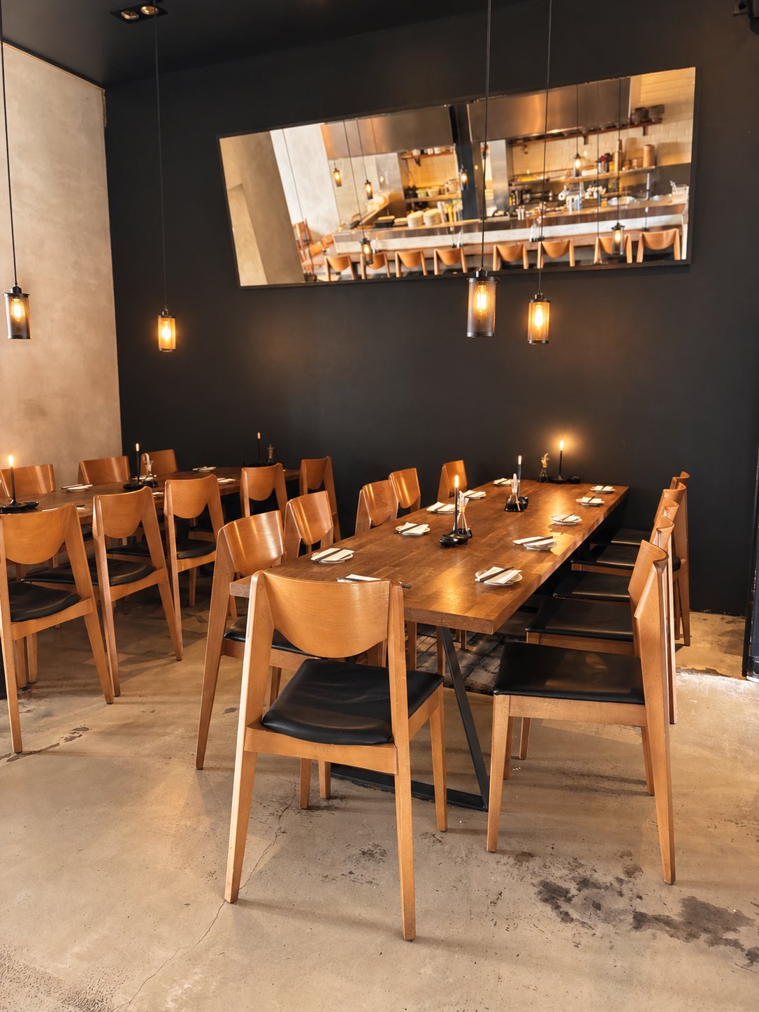 Lange Holztafel mit Kerzen und Holzstühlen im DAIKAN Belgisches Viertel
