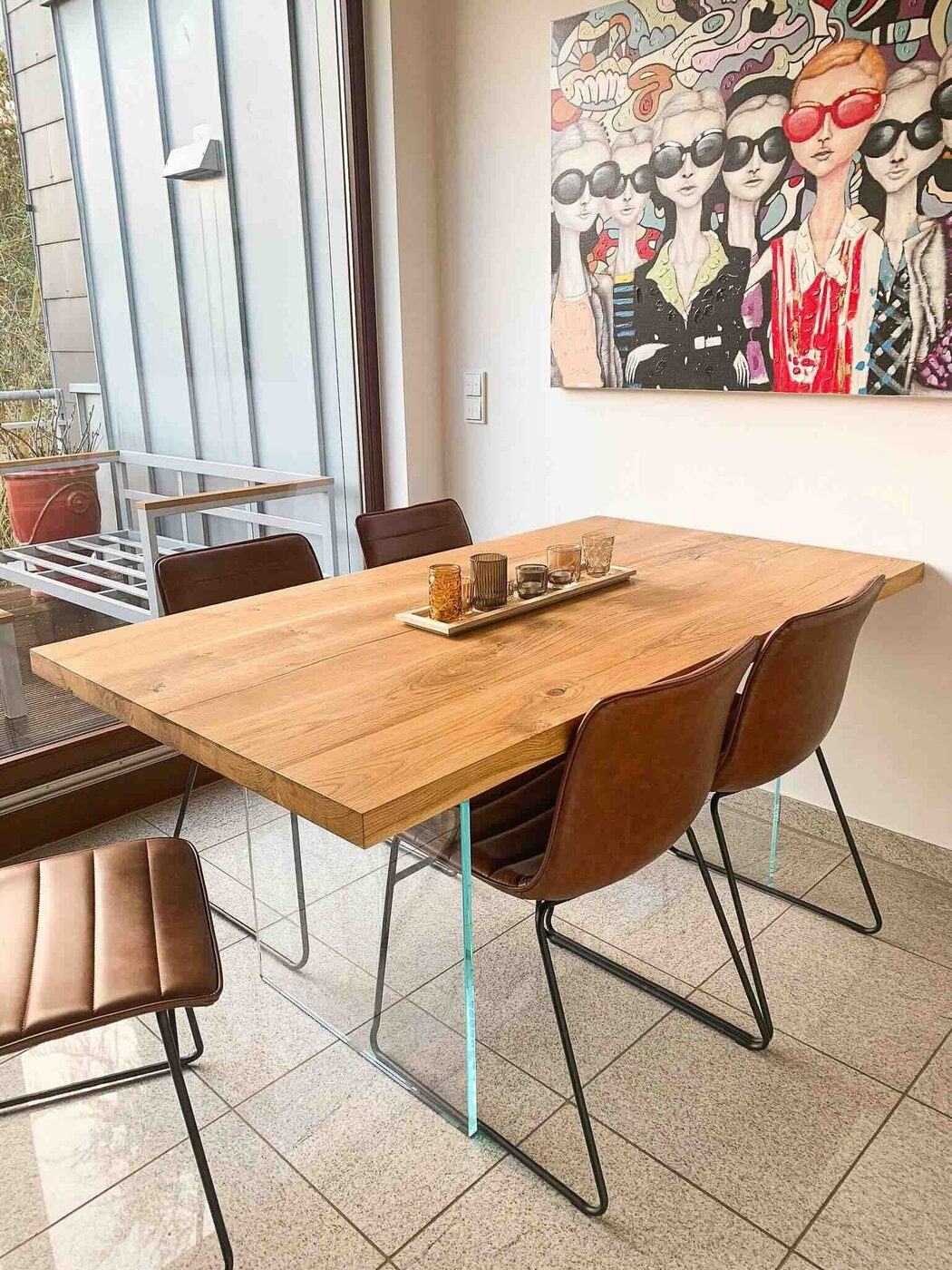 Eichentisch mit Lederstühlen vor einem Kunstwerk
