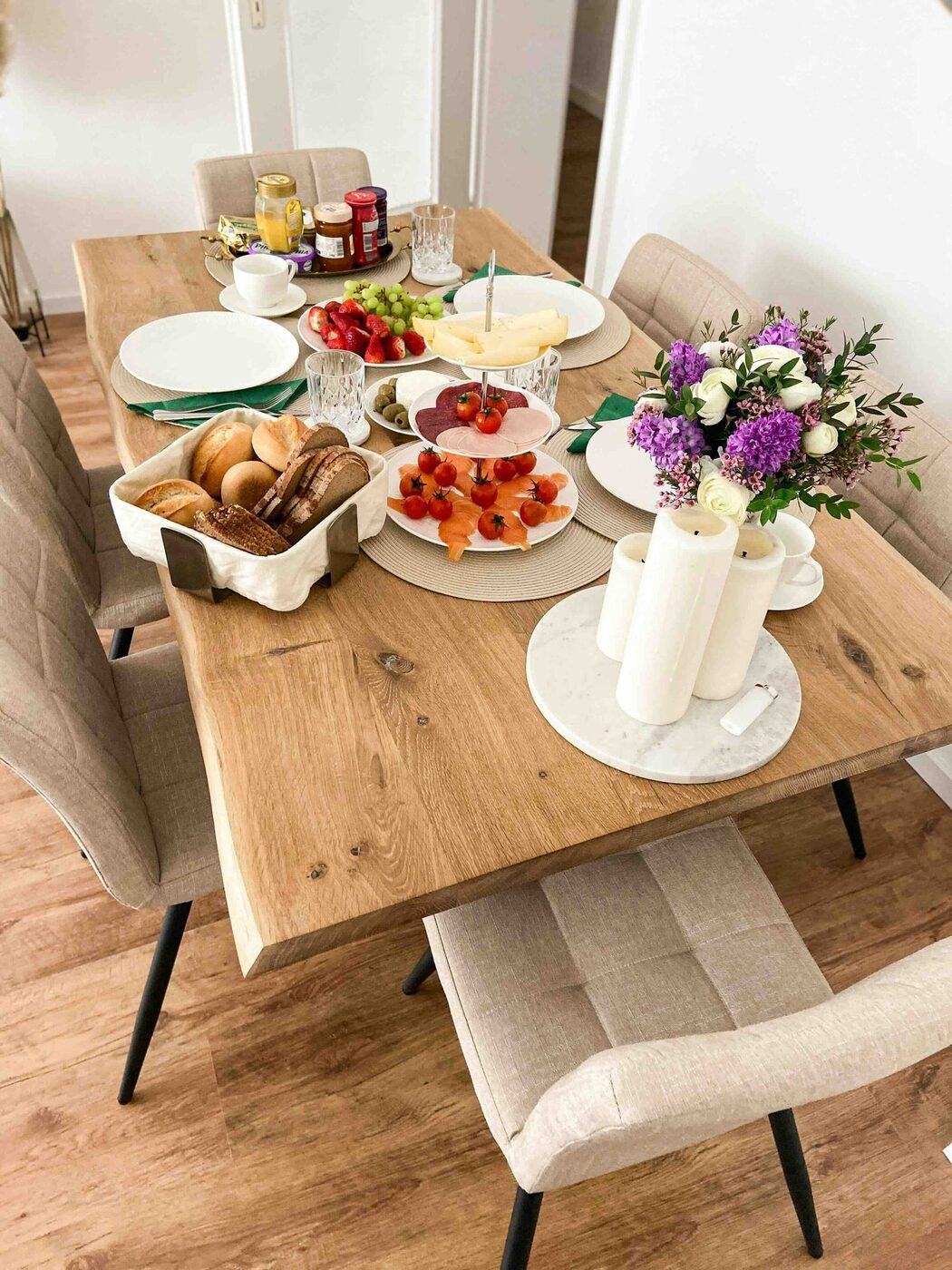 Gedeckter Frühstückstisch mit Gebäck und Blumen
