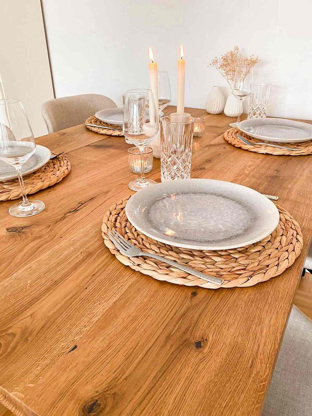 Gedeckter Tisch mit Kerzen und Platzsets
