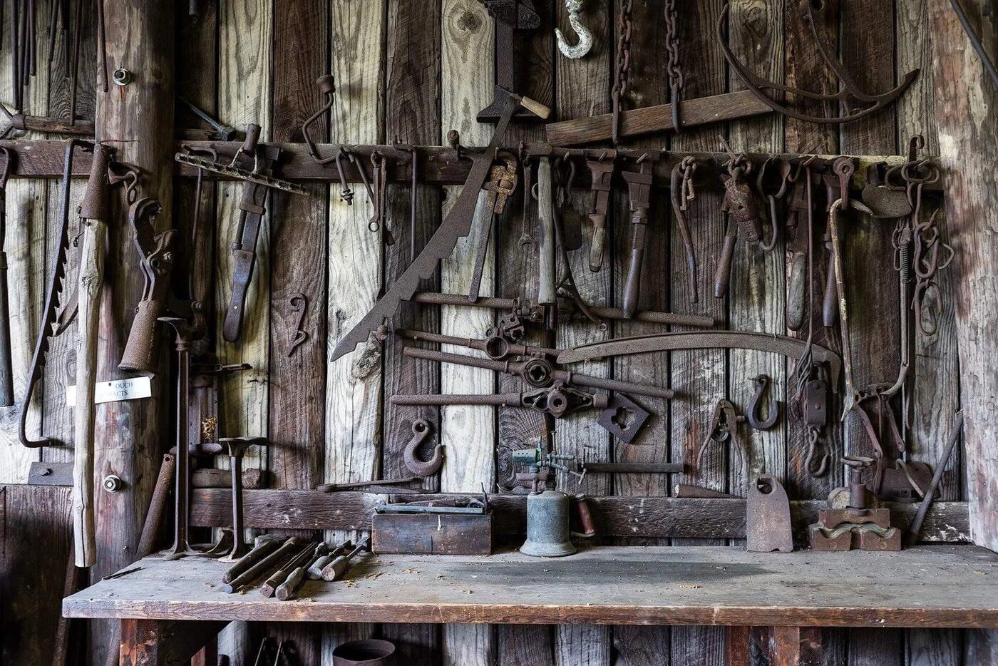 Historische Werkbank mit altem Handwerkzeug an der Holzwand