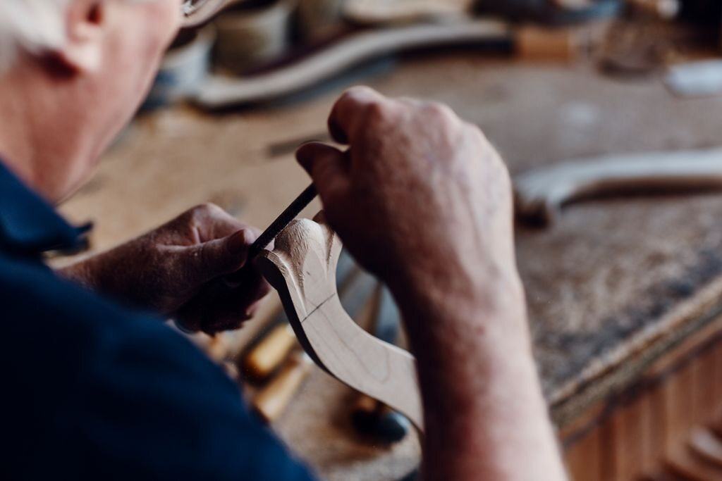 Schreiner formt eine geschwungene Holzkante von Hand