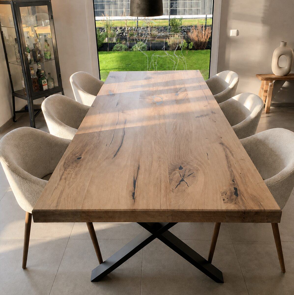 Massive Eichenplatte auf schwarzem X-Gestell im Sonnenlicht